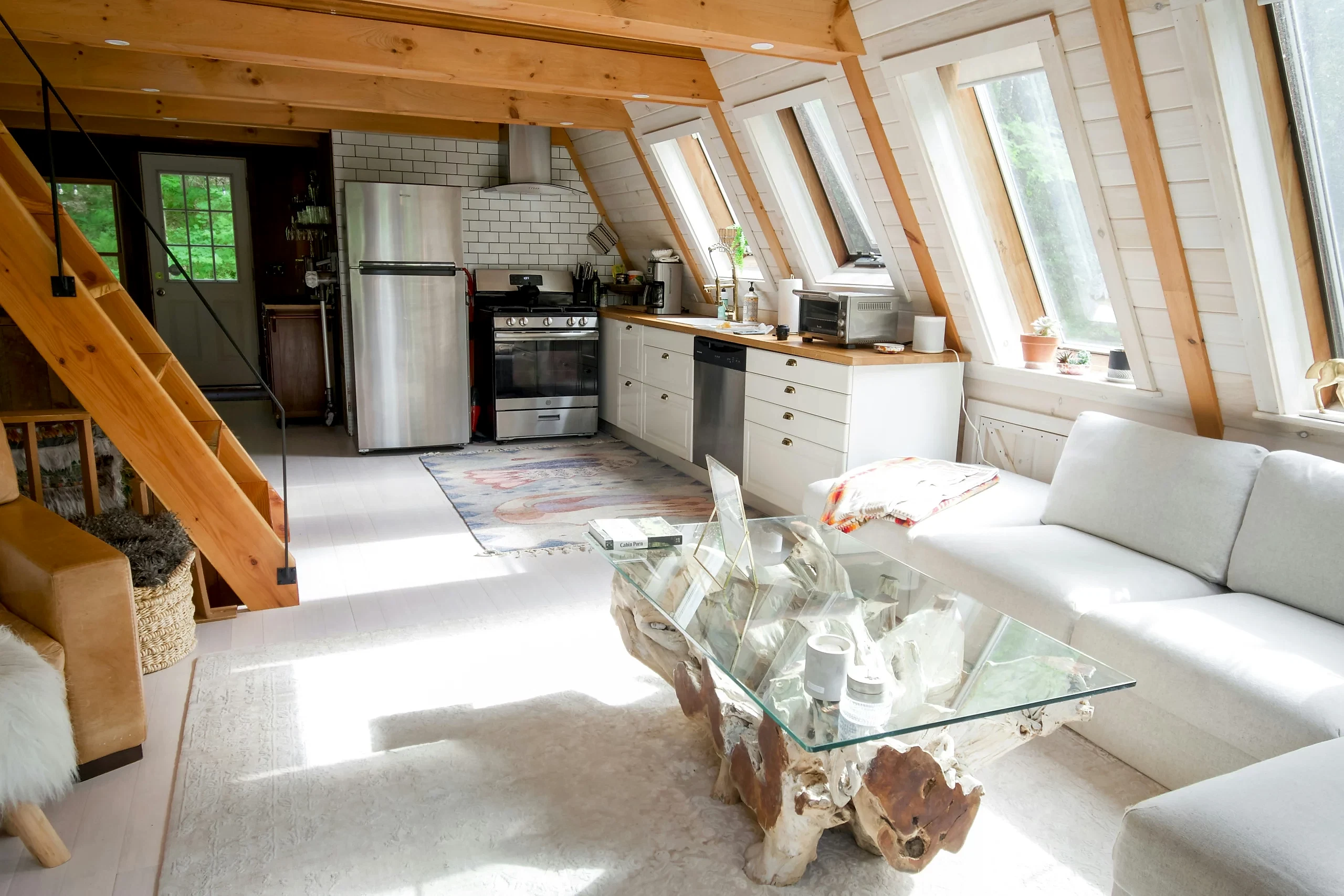 A clean glass table catches sun in the middle of a fresh and spotless Airbnb. 